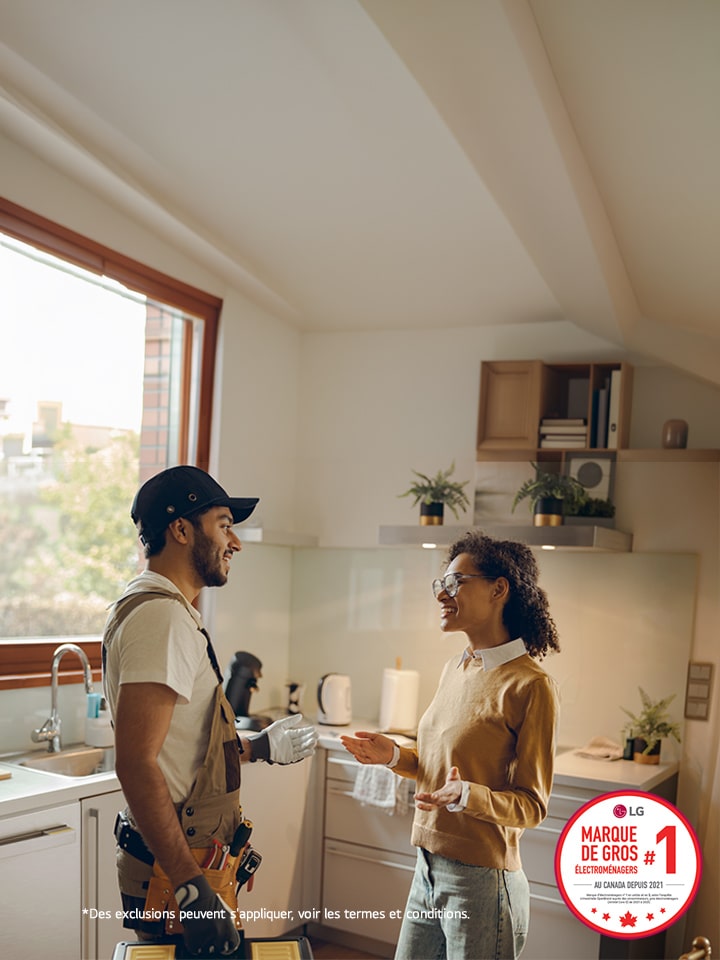 L’installateur discute des réparations à faire avec le client dans la cuisine