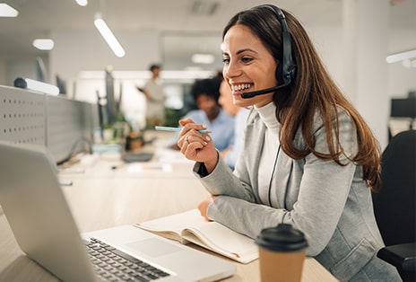 Une femme amicale portant un casque d’écoute aide un client en ligne
