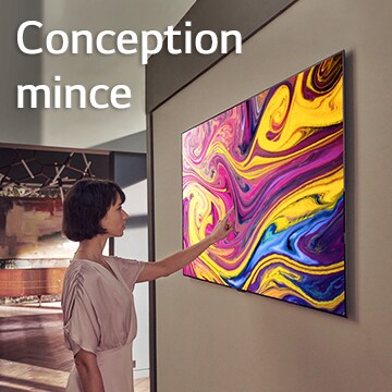 Une femme regarde un téléviseur monté au mur qui affiche un tableau.