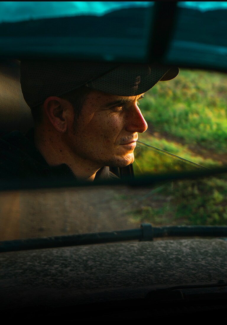 Un reflet d’un homme dans un rétroviseur de voiture. L’image recule pour montrer la même scène sur le téléviseur QNED.