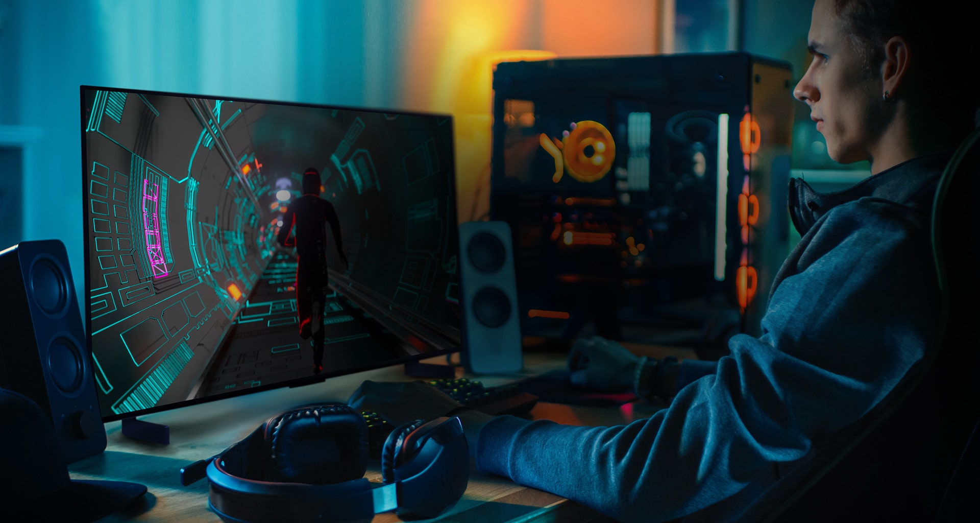 Une personne joue à un jeu de science fiction sur un petit téléviseur OLED de LG à son bureau personnel