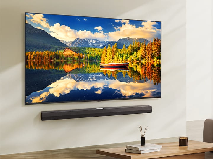 LG NanoCell TV, der in einem modernen Wohnraum an einer Wand über einer LG Soundbar montiert ist. Der LG NanoCell TV zeigt einen farbenfrohen Hintergrund.