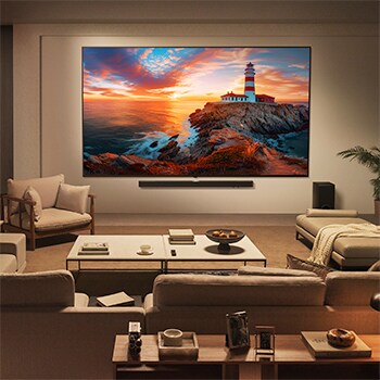 Ein Mädchen und ein Hund sitzen vor einem LG QNED TV, der an einer Wand montiert ist und drei Elefanten zeigt, die über einer LG Soundbar nach außen laufen. Der Titel spricht davon, dass jede Aktion auf einer großen Leinwand noch spannender ist.