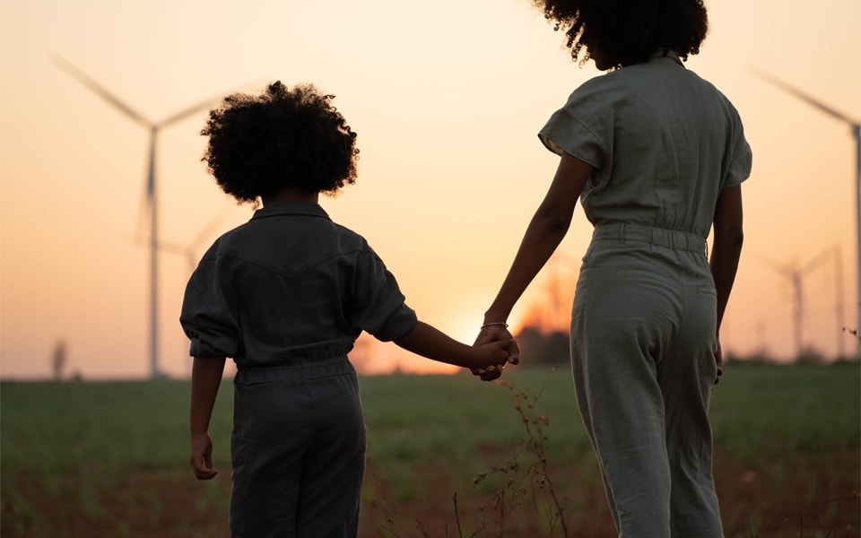 young consumers standing in a field with wind turbines