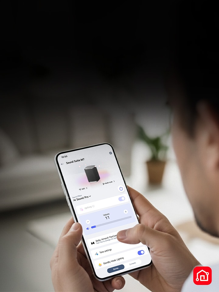 Eine Person, die ein Smartphone mit geöffneter LG ThinQ-App hält, was eine einfache Steuerung der LG Sound Suite zeigt	