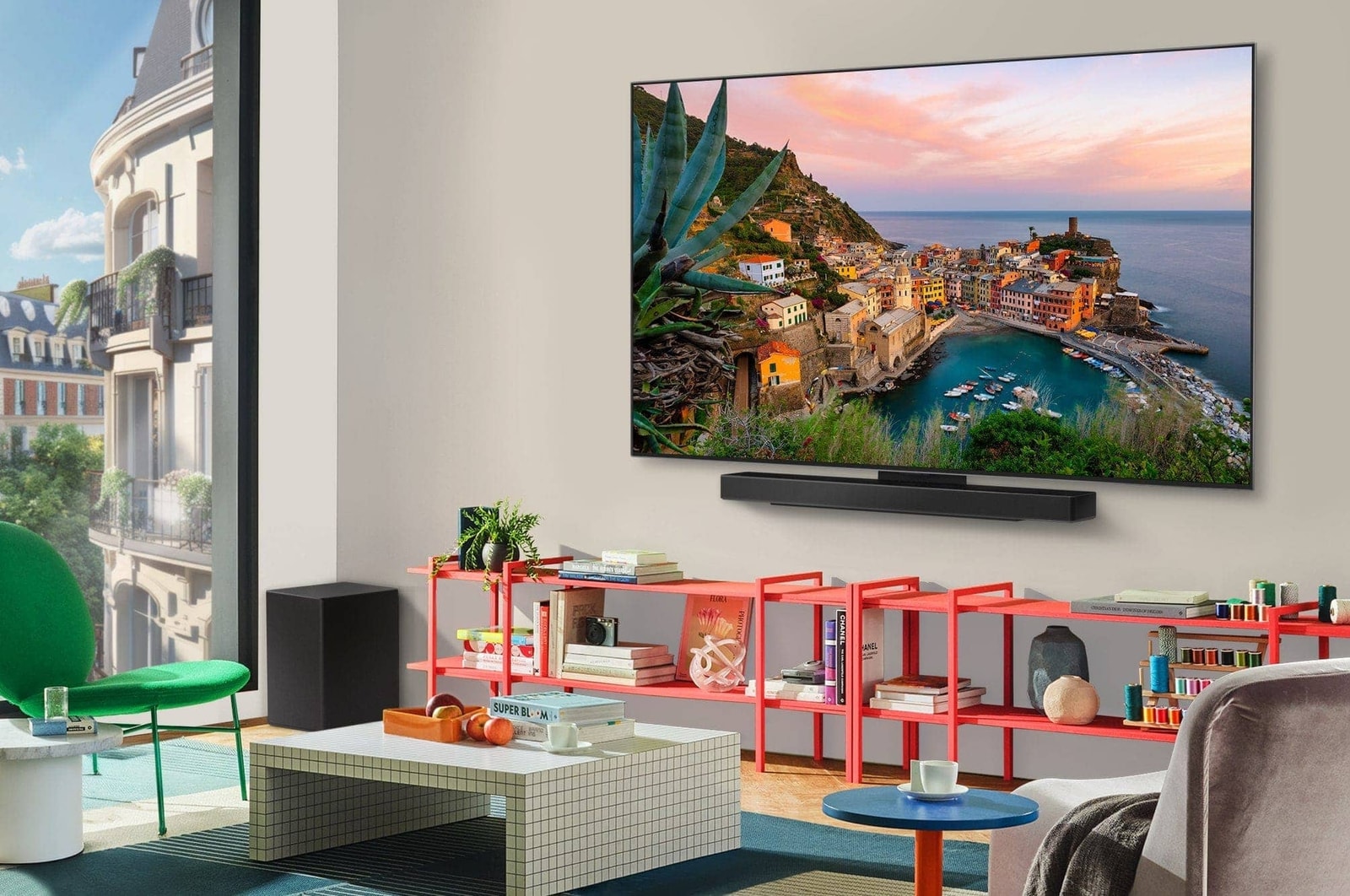 Vue large d’un salon élégant et coloré. La Smart TV LG OLED evo AI C5 4K est fixée au mur avec une LG Soundbar en dessous. Le design de la TV se fond bien dans l’espace. Sur l’écran de TV se trouve une œuvre d’art colorée. 