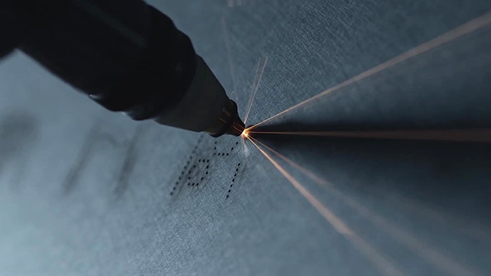 L'icône d'interface du réfrigérateur LG SIGNATURE est sculptée par un outil sur son corps en acier inoxydable.