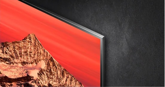 Un ingénieur dans un atelier manipule un contrôleur pour régler une image affichée sur un moniteur.