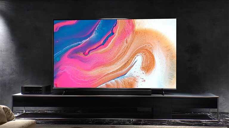Das Installationsvideo zeigt, wie ein schlanker Fernseher in einem dunklen Raum an der Wand montiert wird.