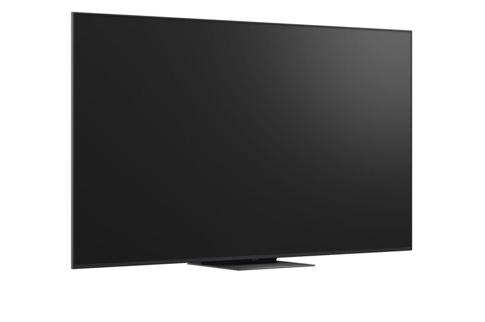 A girl and a dog are seated in front of a LG QNED TV mounted on a wall depicting three elephants walking outwards above a LG Soundbar. The title talks about how every action is more thrilling on a massive screen.