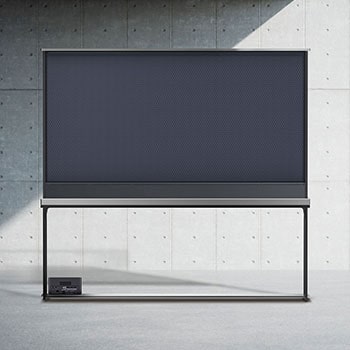 Salon d’un appartement-terrasse avec une LG Signature OLED T près de baie vitrée panoramique. L’extérieur offre une vue superbe sur un paysage urbain au bord d’un plan d’eau. Sur l’écran de TV se trouve un yacht, mais comme la TV est en mode transparent, le yacht semble flotter vraiment dans l’eau à l’extérieur.