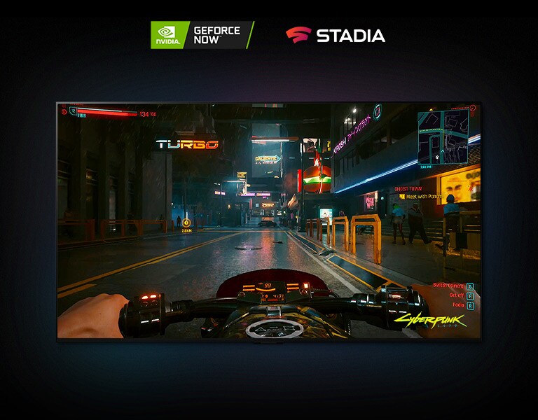 Dans une scène Cyberpunk 2077 diffusée sur un écran LG OLED, le joueur conduit une moto dans une rue éclairée au néon
