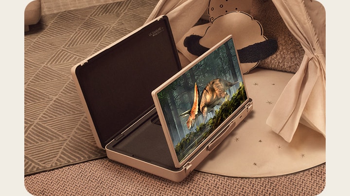 El estuche de la televisión LG StanbyME Go está abierto y la pantalla está desplegada. Dos niños en casa en un campamento improvisado con una tienda y luces cálidas y acogedoras. Están viendo un video en la pantalla de la StanbyME Go.