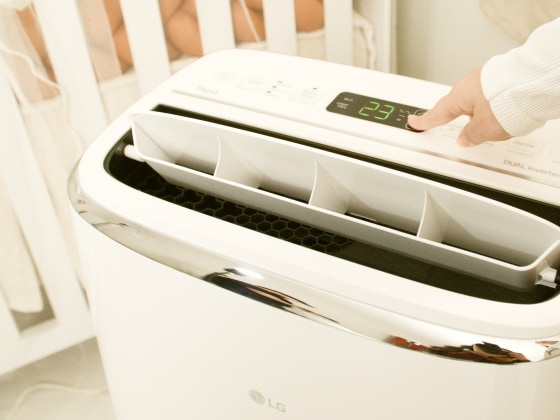 Una persona ajusta el aire acondicionado portátil LG ThinQ a 23 °C.