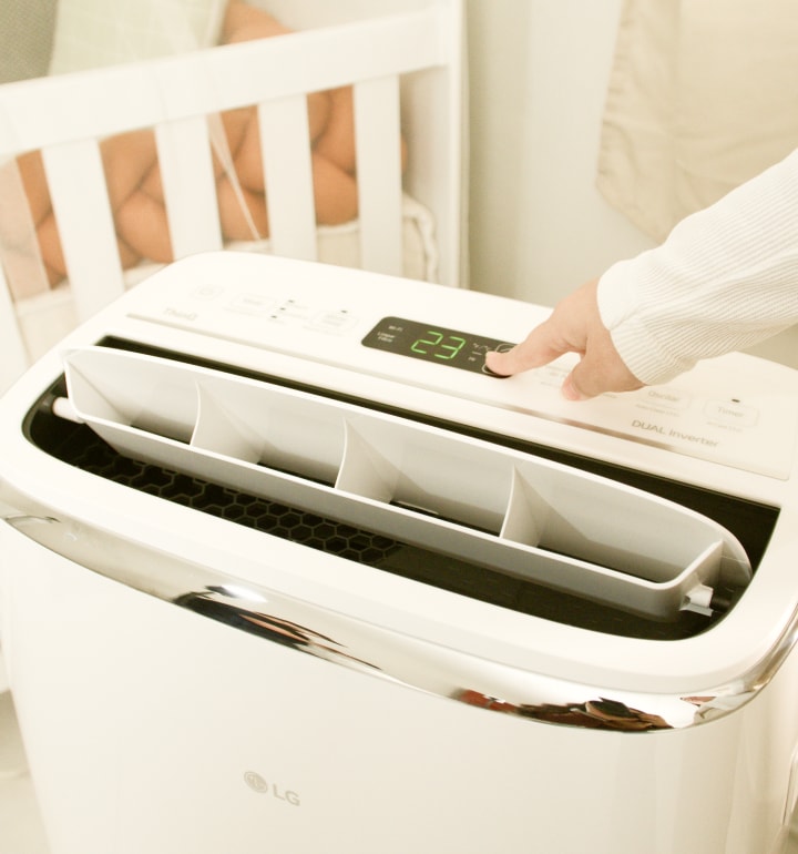 Una persona ajusta el aire acondicionado portátil LG ThinQ a 23 °C.