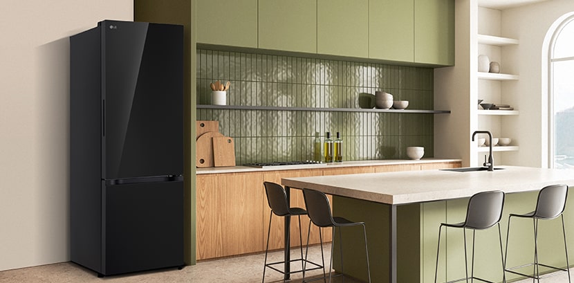 La vista lateral del refrigerador LG bottom freezer con instaview con armarios verdes y una elegante isla.