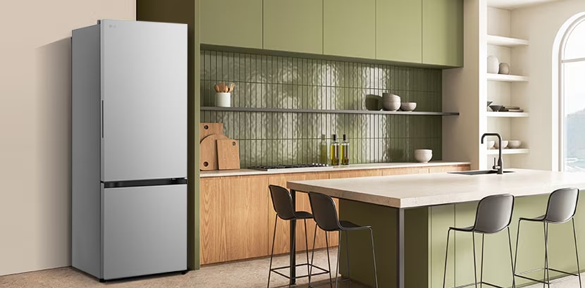La vista lateral del refrigerador LG bottom freezer con instaview con armarios verdes y una elegante isla.