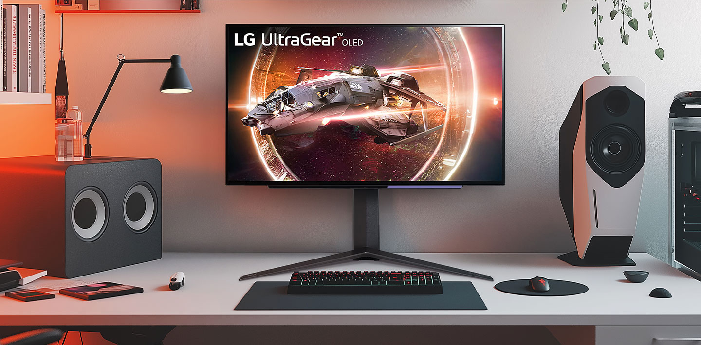 Monitor LG UltraGear mostrando un juego de naves espaciales en una estación de juegos con parlantes y PC.