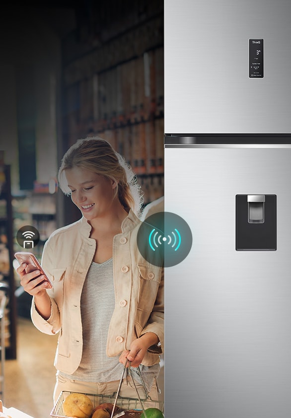 Mujer controla a distancia un refrigerador LG con su smartphone. Destaca la conectividad inteligente del frigorífico.
