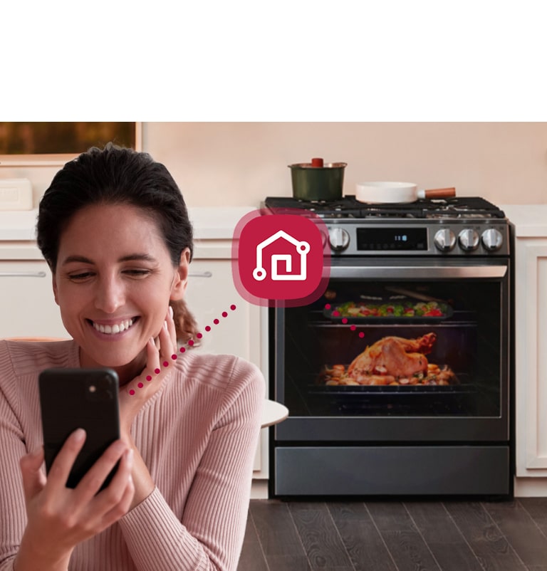 Mujer controlando remotamente la estufa LG lrgl5847s por el smartphone con la tecnología ThinQ