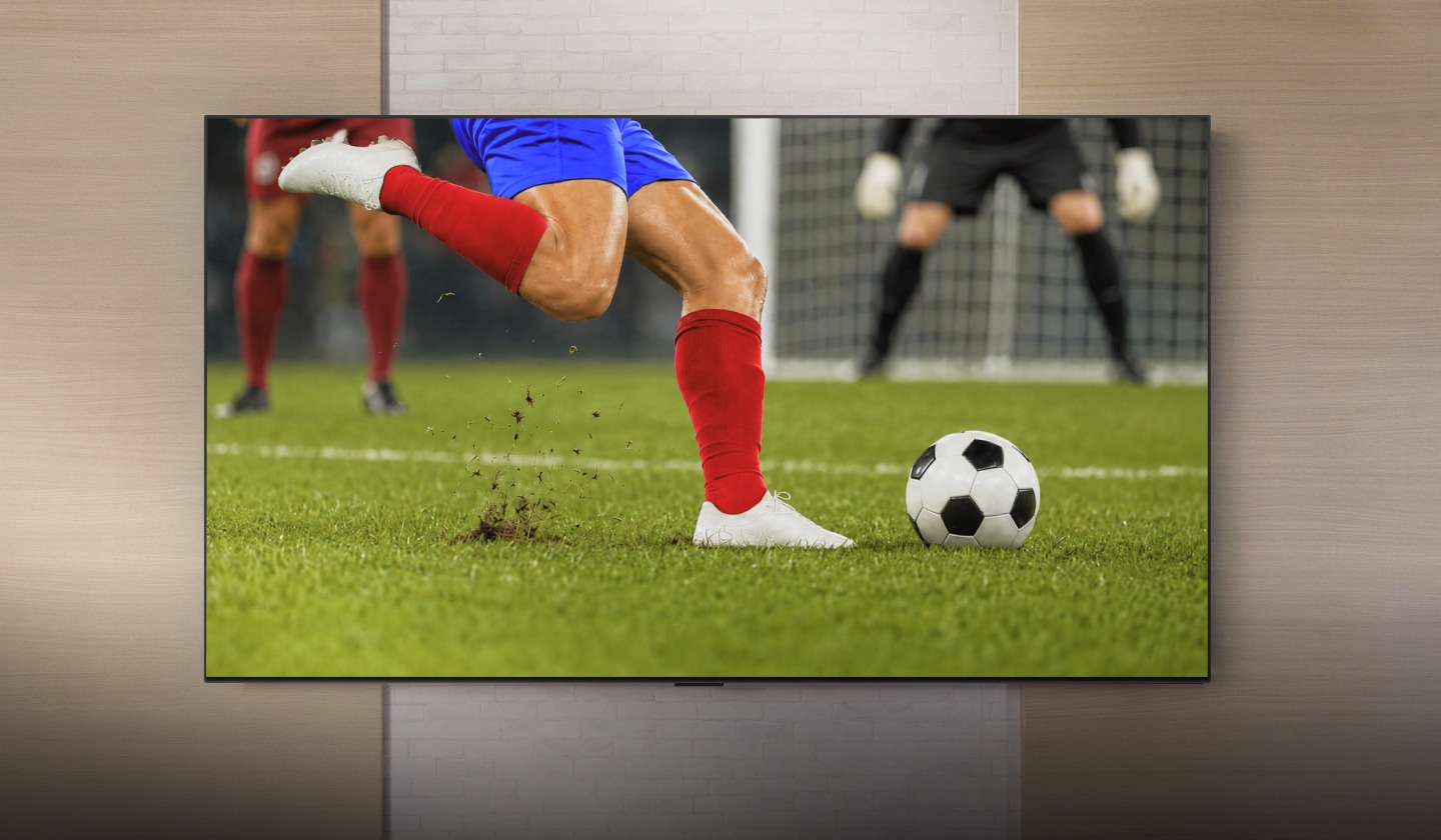 Primer plano de un futbolista en acción en una gran TV LG de pared.