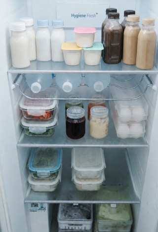 Bebidas, yogur, huevos y recipientes con porciones de papilla están organizados en los estantes de la nevera.