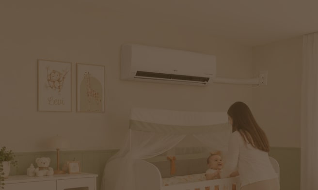 Una madre que lleva a su bebé en un portabebés prepara alimentos en una cocina moderna y luminosa, junto a un refrigerador LG.