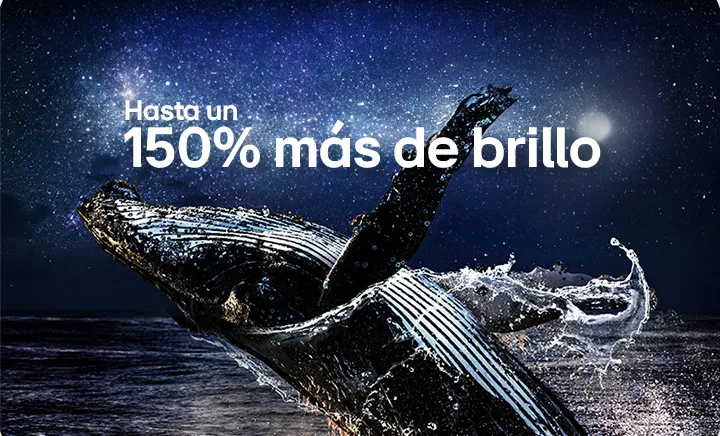 Una imagen fija de una ballena saltando desde un océano oscuro bajo un cielo nocturno estrellado, luego las palabras "Hasta 150 % más brillante" se desvanecen en el cielo.