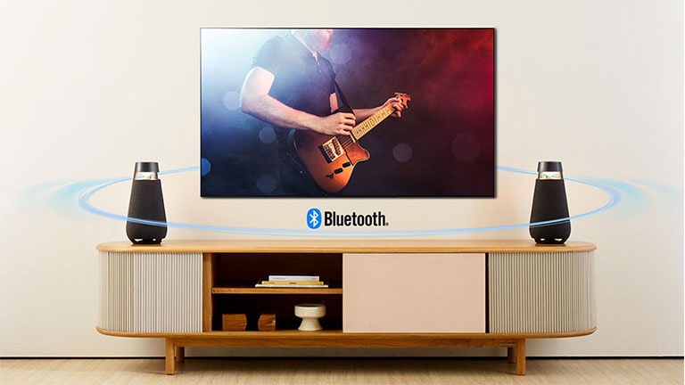 Dos XO3 están colocados en el estante del televisor. Se conectan a la TV con Bluetooth y se muestra la onda de sonido por toda la sala de estar.