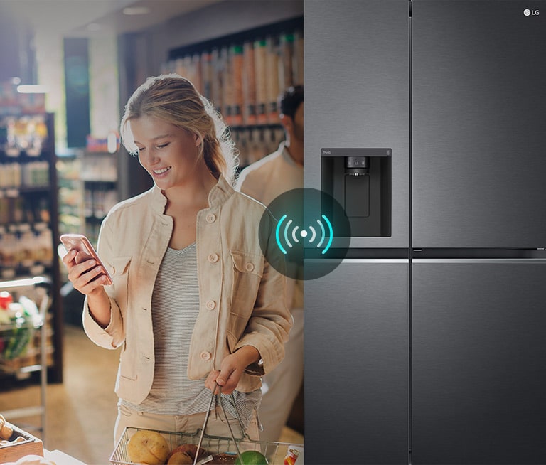 Mujer en supermercado conecta su teléfono al refrigerador LG con LG ThinQ.