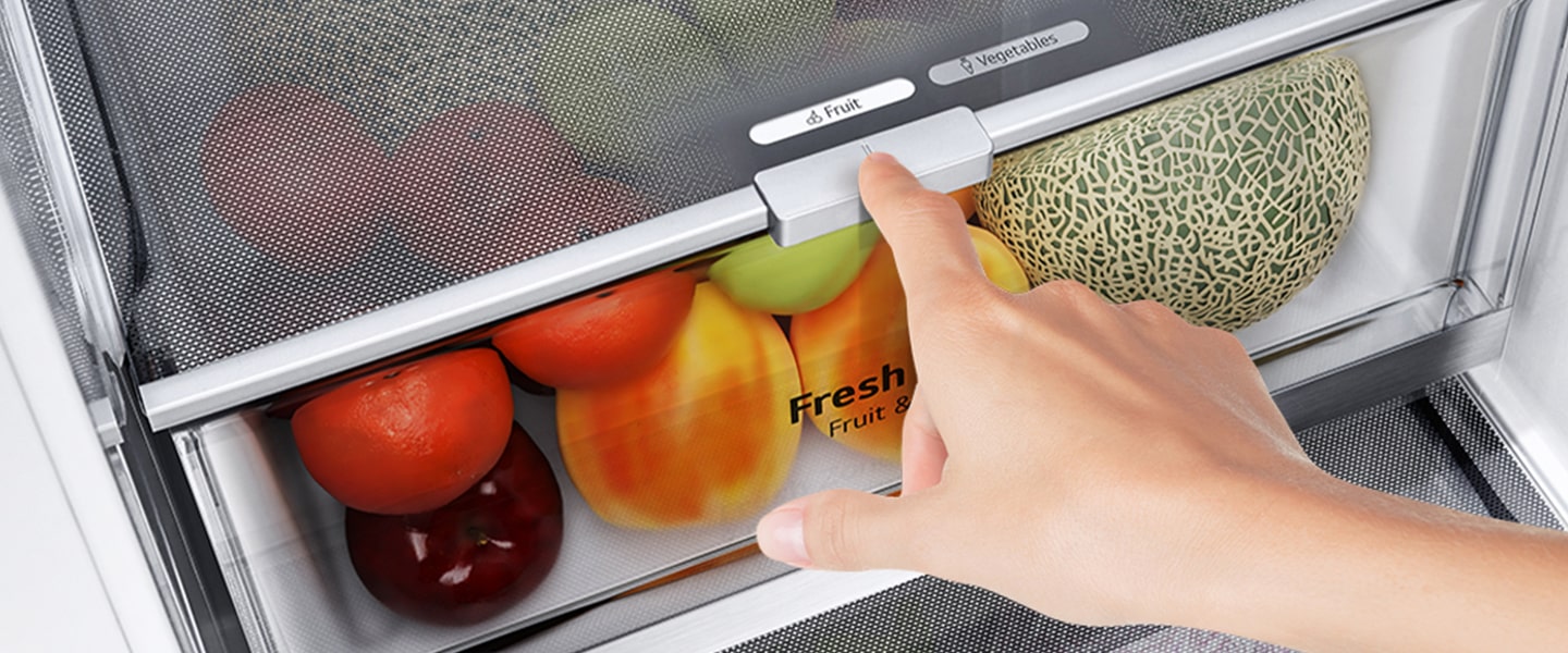 Los cajones inferiores del refrigerador están llenos de coloridos productos frescos. Una imagen ampliada muestra la palanca de control para elegir el nivel de humedad óptimo para mantener los productos frescos.