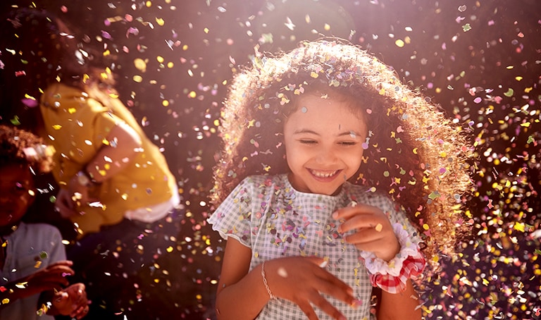Esta tarjeta describe la calidad del sonido. Es una imagen de una niña sonriendo alegremente en celebración.