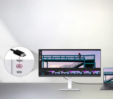 Cable USB-C conectado a portátil y monitor mostrando edición de video, con detalle del puerto USB-C