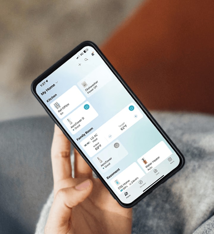 Una persona sostiene un teléfono inteligente con la aplicación LG ThinQ abierta y administra dispositivos domésticos inteligentes mientras toma café.