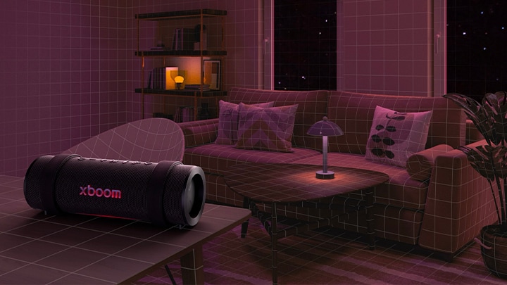En una habitación con luces rosas, un sofá blanco y una mesa están al fondo. El xboom Grab está sobre una mesa blanca.