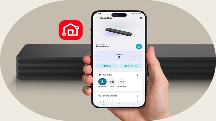 Teléfono con la app LG ThinQ en pantalla y su ícono. La barra SH5A está colocada detrás.