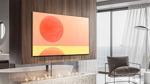 Un TV LG OLED G2 está colgado en la pared de una habitación marrón y blanca con accesorios de color rojo