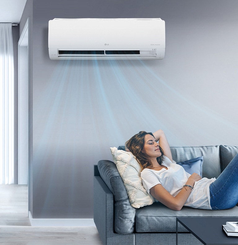Mujer descansa en sofá bajo aire acondicionado LG. Corrientes azules indican enfriamiento eficiente del ambiente