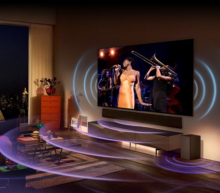 En una acogedora sala de estar, un televisor grande y una barra de sonido están montados en la pared. A ambos lados del televisor y debajo de la barra de sonido, hay un diseño gráfico de ondas que se extiende de forma amplia y grandiosa a través del sonido.