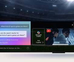 Detail obrazovky televizoru LG QNED TV zobrazující, jak funguje funkce AI Search. Otevře se malé okno chatu, ve kterém se zobrazí, jak se uživatel ptal na nabídku sportovních her. AI vyhledávání reagovalo prostřednictvím chatu a zobrazováním miniatur dostupného obsahu. Zobrazí se také výzva, abyste se obrátili na Microsoft Copilot.
