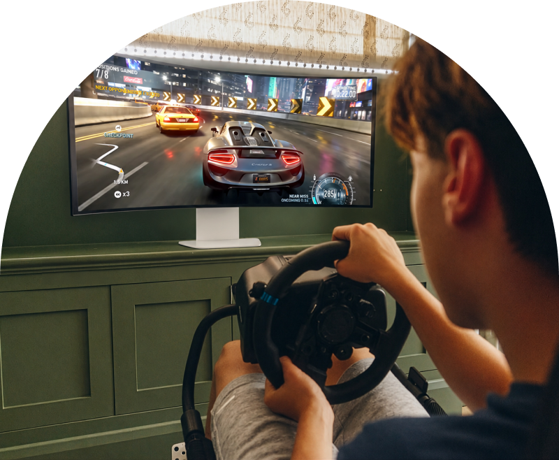 Student si užívá závodní hru na herním monitoru LG UltraGear s volantem.