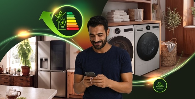Usmívající se muž se dívá do smartphonu, zatímco v pozadí je vidět chladnička, pračka a sušička. Obrázek obsahuje ikonu energetického štítku a solárních panelů, které zdůrazňují energetickou účinnost spotřebičů.