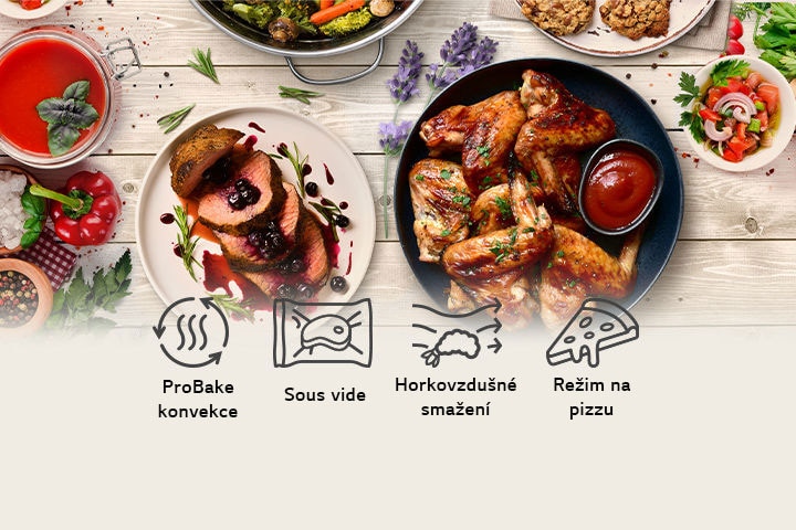 Na tomto obrázku jsou na stole kuřecí prsa vařená v páře, kuřecí křídla smažená na vzduchu, sušenky a steak připravený metodou sous vide. Níže jsou také uvedeny ikony představující funkce ProBake konvekce, sous vide, horkovzdušné smažení a ProBake parní pečení.