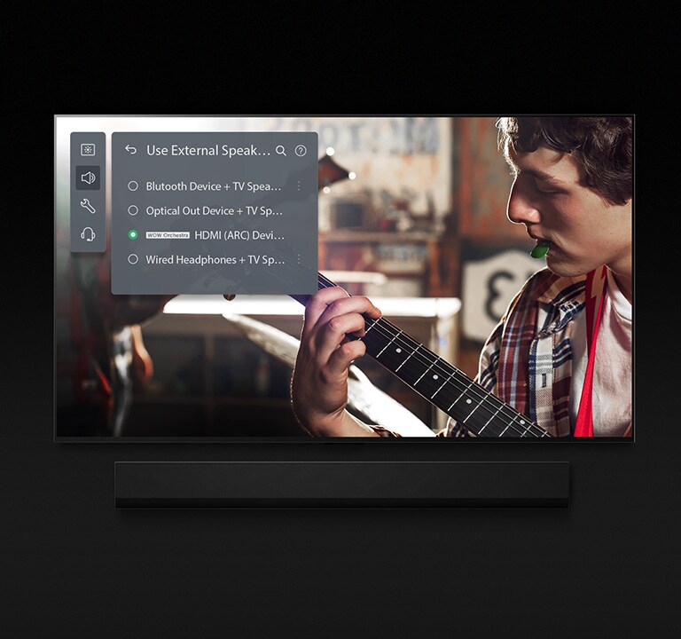Snímek televizoru LG OLED TV se Soundbarem. Na obrazovce se přehrává video chlapce hrajícího na kytaru, na kterém je překryto nastavení režimu Soundbar.
