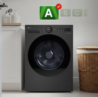 V prádelně je umístěna černá pračka LG s energetickým štítkem A. Vedle pračky stojí hnědý koš na prádlo.