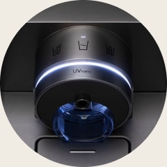 Detailní pohled na UVnano dávkovač LG z roku 2020 se zapnutým modrým UV LED světlem u výstupu na vodu.