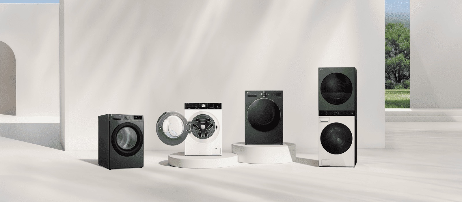 LG washer and dryer lineup in front of a beige wall. Includes a tumble dryer, front load washer with open door, washer dryer combo, and WashTower. A forest view is visible on the right.