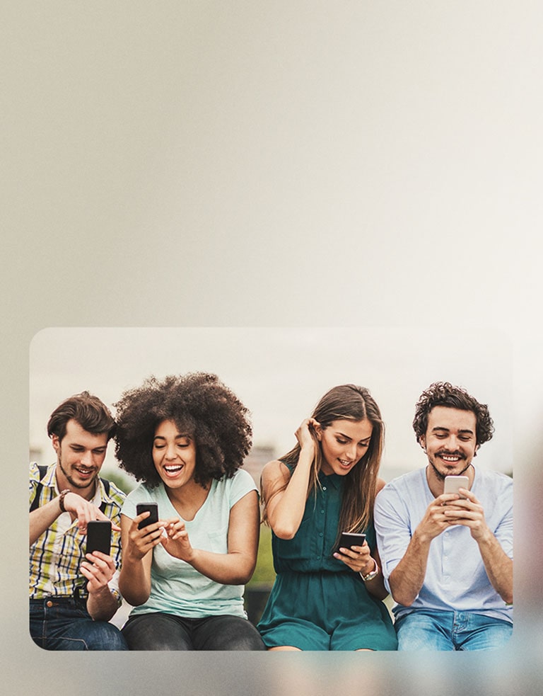 Čtyři lidé sedí vedle sebe, každý drží smartphone. Sdílejí užitečné informace, usmívají se a projevují zájem o diskusi. Scéna působí uvolněně a přátelsky, s pocitem propojení a spolupráce mezi nimi.