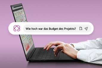 Dieses Bild zeigt Hände, die auf einem Laptop tippen. In der Suchleiste ist die Frage „Wie hoch war das globale Projektbudget?“ angezeigt.