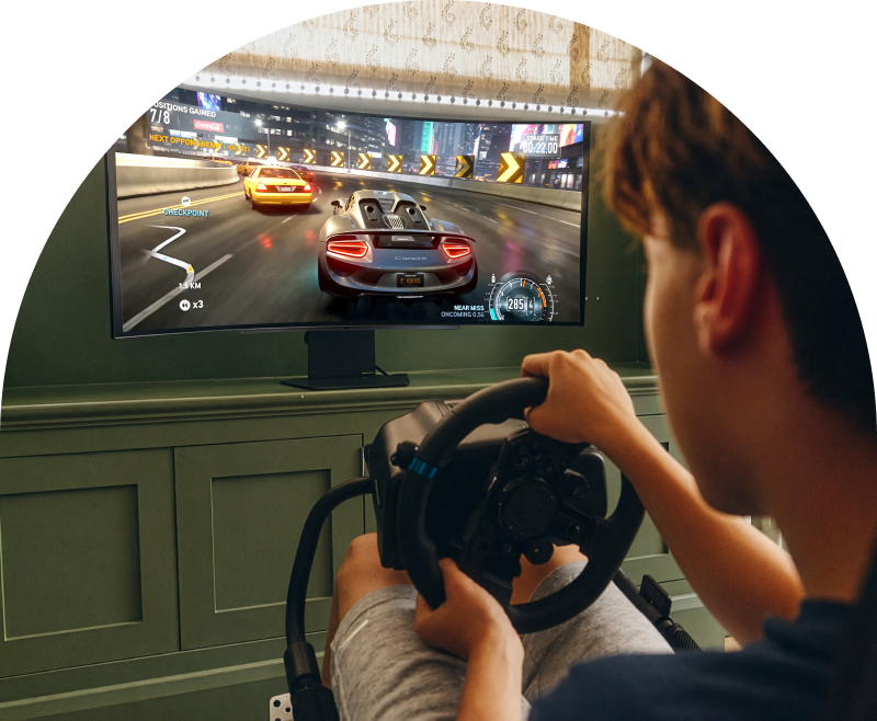 Schüler genießt ein Rennspiel auf einem LG UltraGear Gaming-Monitor mit einem Lenkrad.